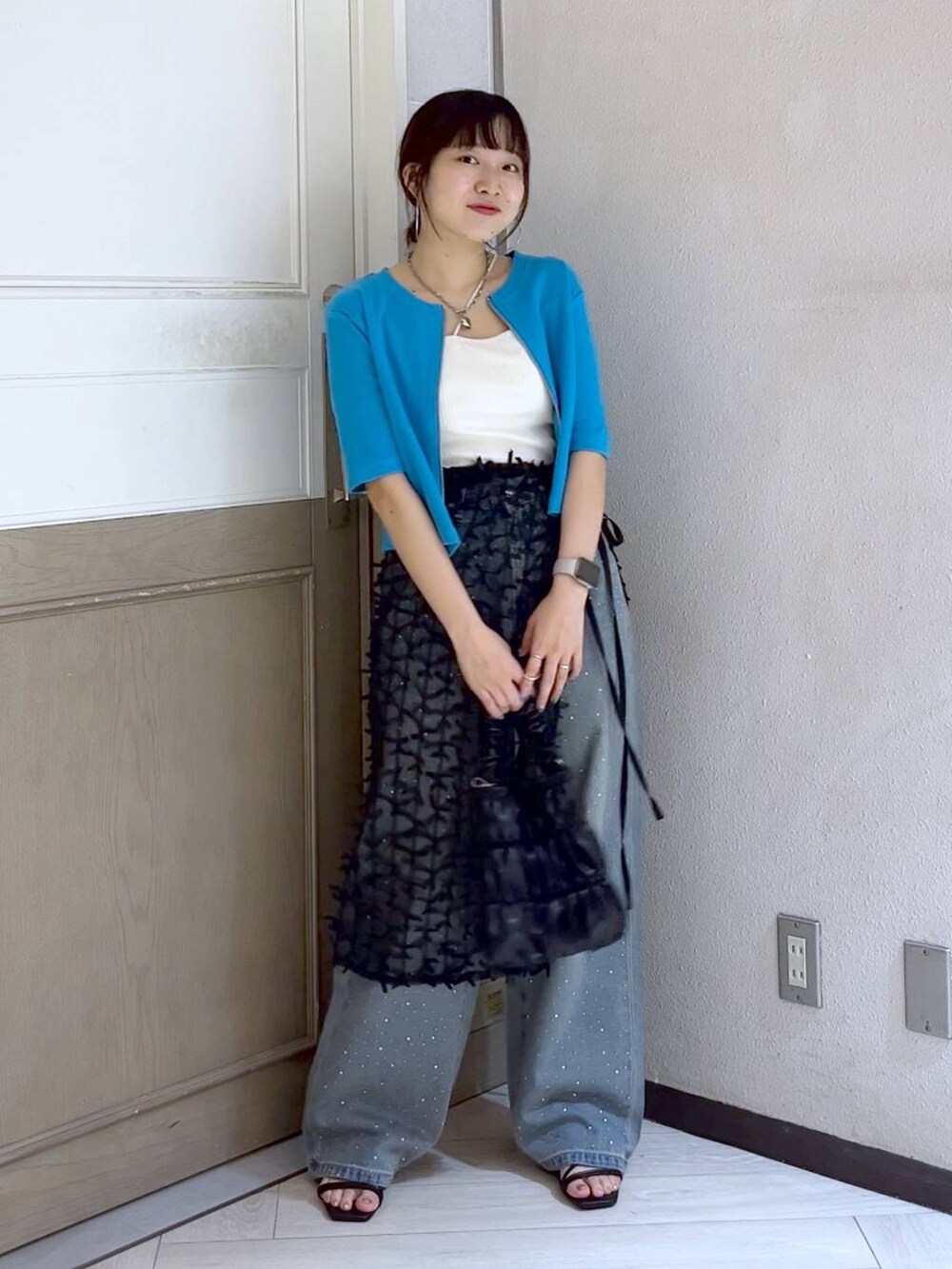 ブラック系のサンダル、ブルー系のデニムパンツ、ブラック系のショルダーバッグを着用したレディースの夏コーディネートの2枚目の写真