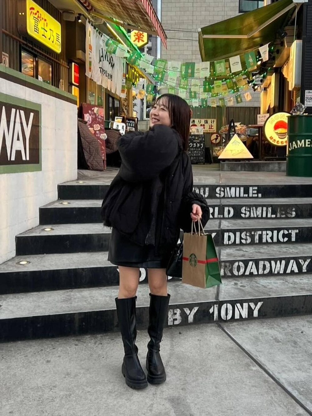 ブラック系のその他アウター、ブラック系のスカート、ブラック系のブーツを着用したレディースの冬コーディネートの2枚目の写真