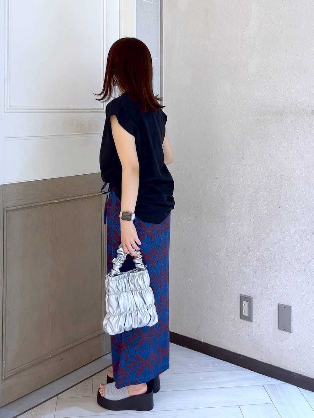 シルバー系のサンダル、グレー系のショルダーバッグ、ブラック系のTシャツ/カットソーを着用したレディースの夏コーディネートの3枚目の写真