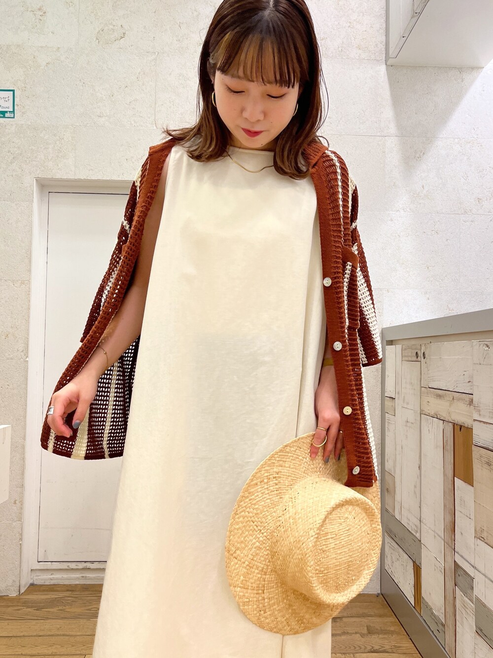 ホワイト系のワンピース、ブラウン系のトップス、ブラック系のシューズを着用したレディースの春コーディネートの5枚目の写真