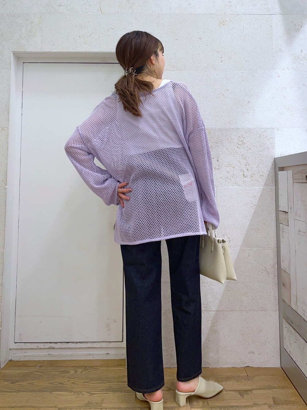 パープル系のカーディガン/ボレロ、ブルー系のパンツ、ホワイト系のバッグを着用したレディースの春コーディネートの2枚目の写真