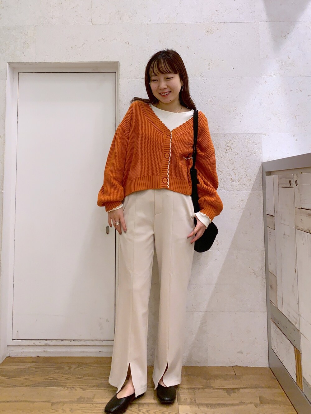 ブラウン系のトップス、ホワイト系のトップス、ホワイト系のパンツを着用したレディースの春コーディネートの2枚目の写真