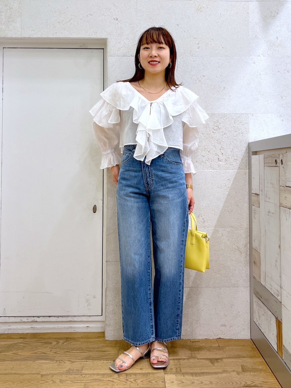 ホワイト系のシャツ/ブラウス、ブルー系のパンツ、イエロー系のバッグを着用したレディースの夏コーディネートの3枚目の写真