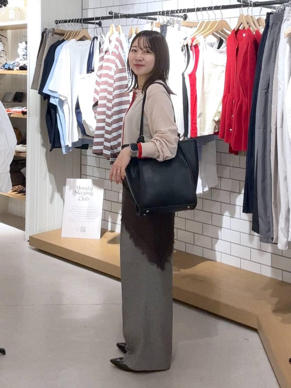 ブラック系のパンプス、グレー系のデニムパンツ、ベージュ系のカーディガン/ボレロを着用したレディースの春コーディネートの3枚目の写真