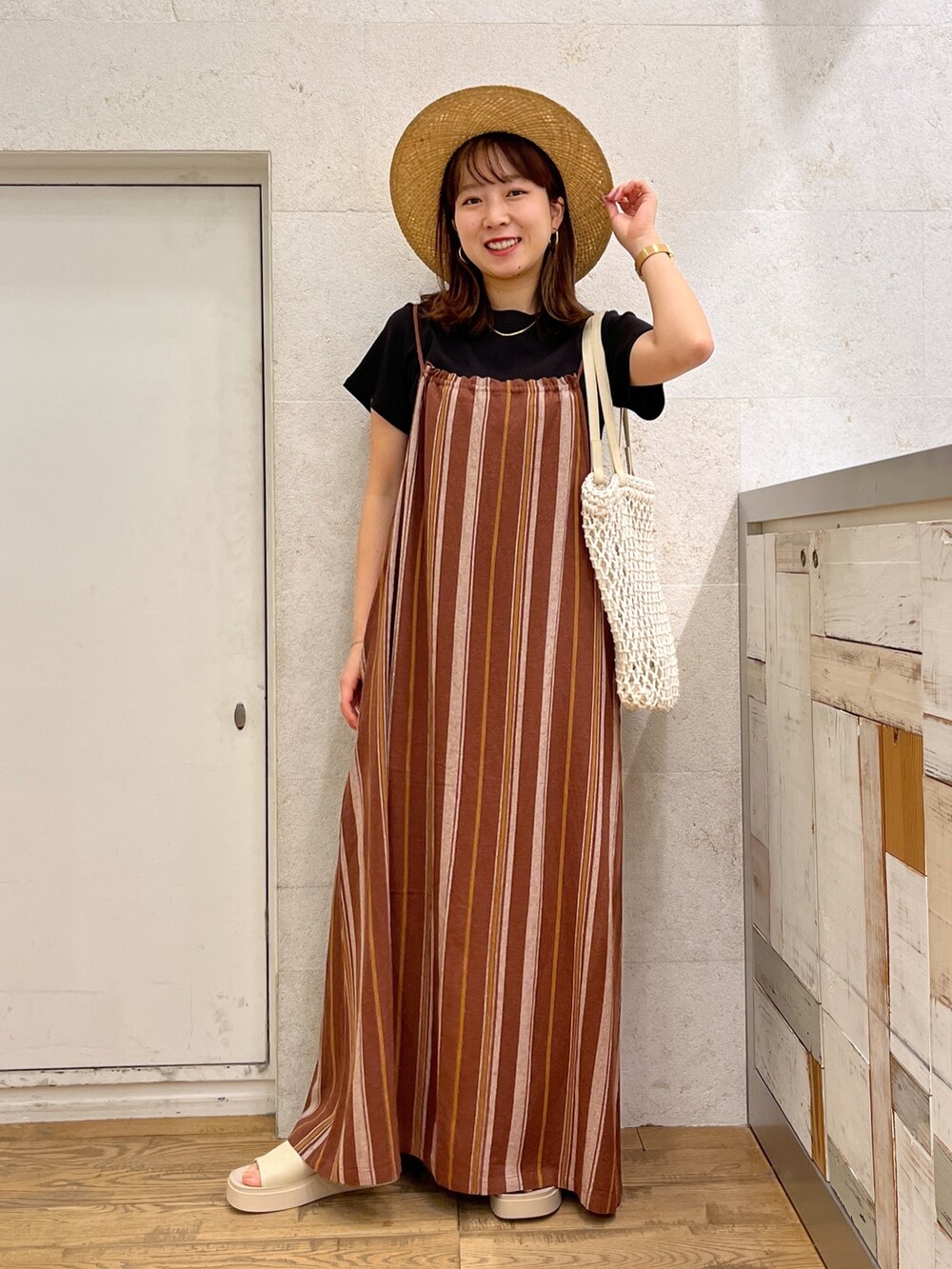 ブラック系のTシャツ/カットソー、ブラウン系のワンピース、ホワイト系のトートバッグを着用したレディースの春コーディネートの2枚目の写真