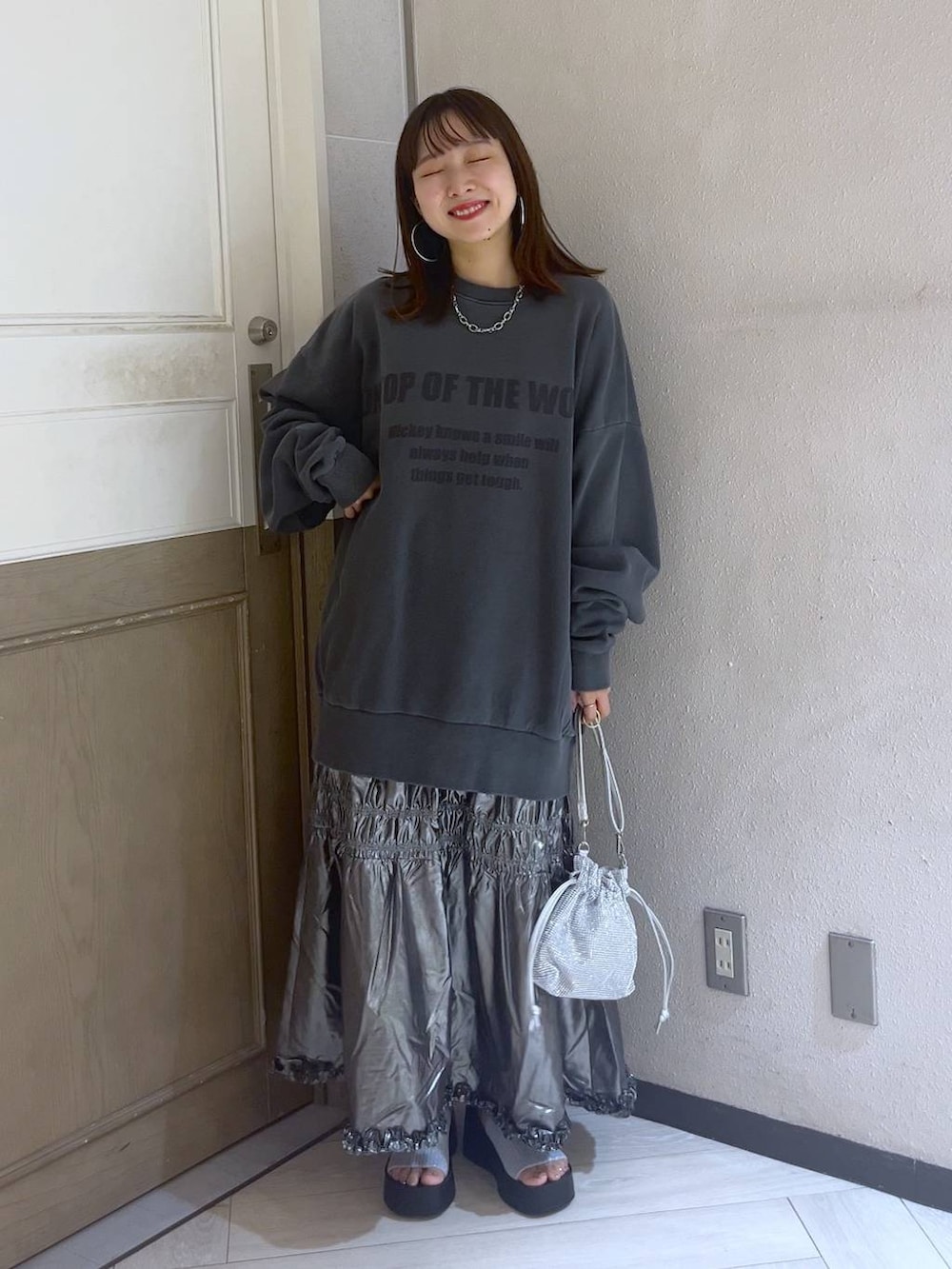 シルバー系のサンダル、シルバー系のショルダーバッグ、シルバー系のスカートを着用したレディースの夏コーディネートの4枚目の写真