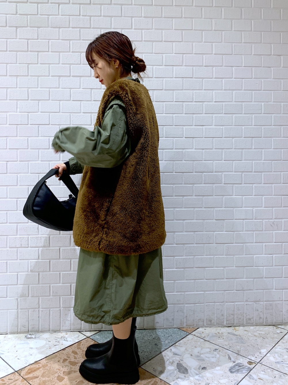 ブラウン系のジャケット/アウター、グリーン系のジャケット/アウター、ブラック系のショルダーバッグを着用したレディースの秋コーディネートの3枚目の写真