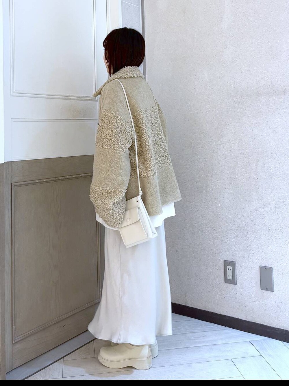 ホワイト系のスウェット、ホワイト系のショルダーバッグ、ホワイト系のスカートを着用したレディースの冬コーディネートの2枚目の写真