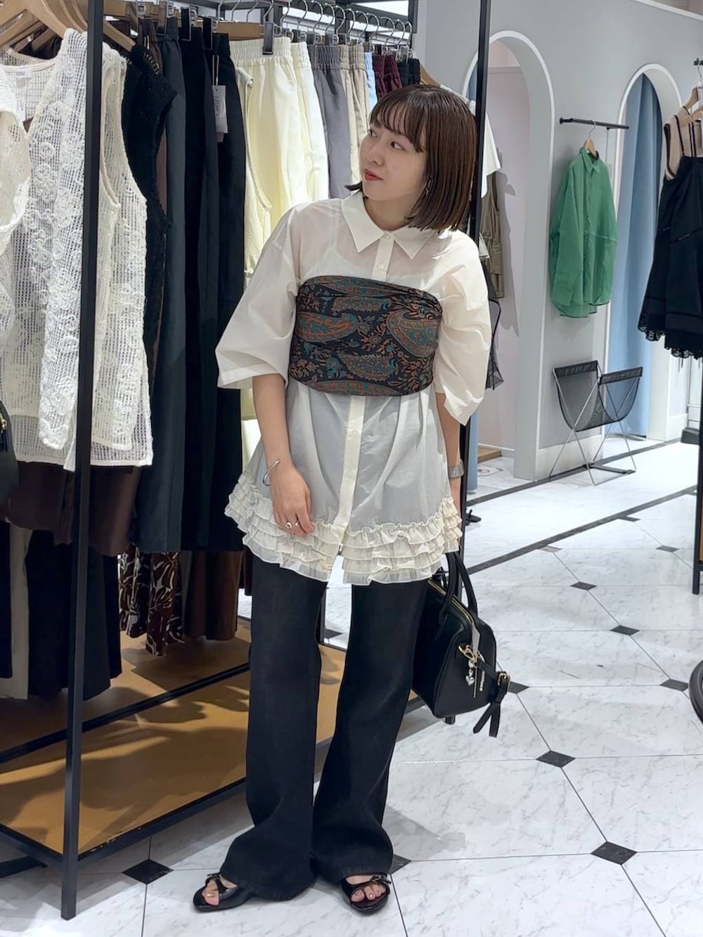 ブラック系のサンダル、ブラック系のショルダーバッグ、ブラック系のデニムパンツを着用したレディースの夏コーディネートの2枚目の写真