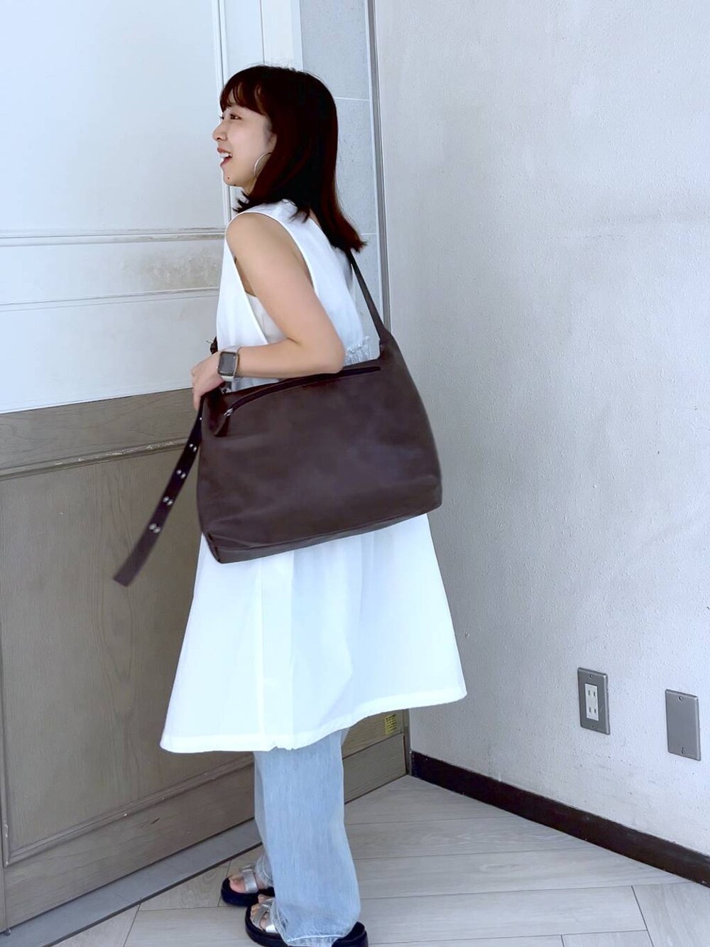 ホワイト系のTシャツ/カットソー、シルバー系のスニーカー、ブルー系のデニムパンツを着用したレディースの夏コーディネートの3枚目の写真