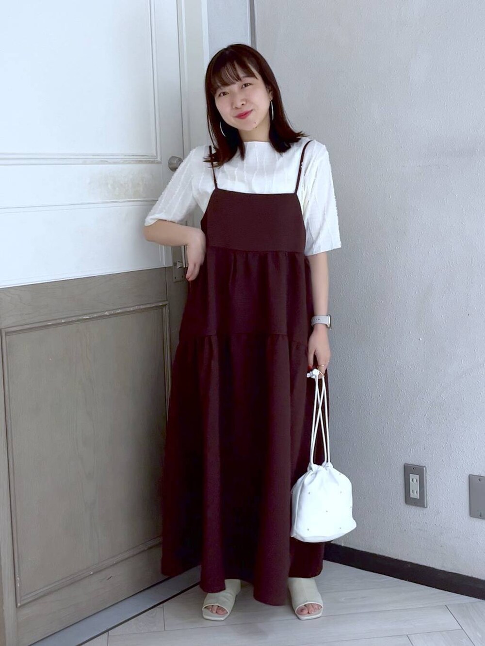 ホワイト系のショルダーバッグ、ブラウン系のワンピース、ホワイト系のTシャツ/カットソーを着用したレディースの夏コーディネートの2枚目の写真