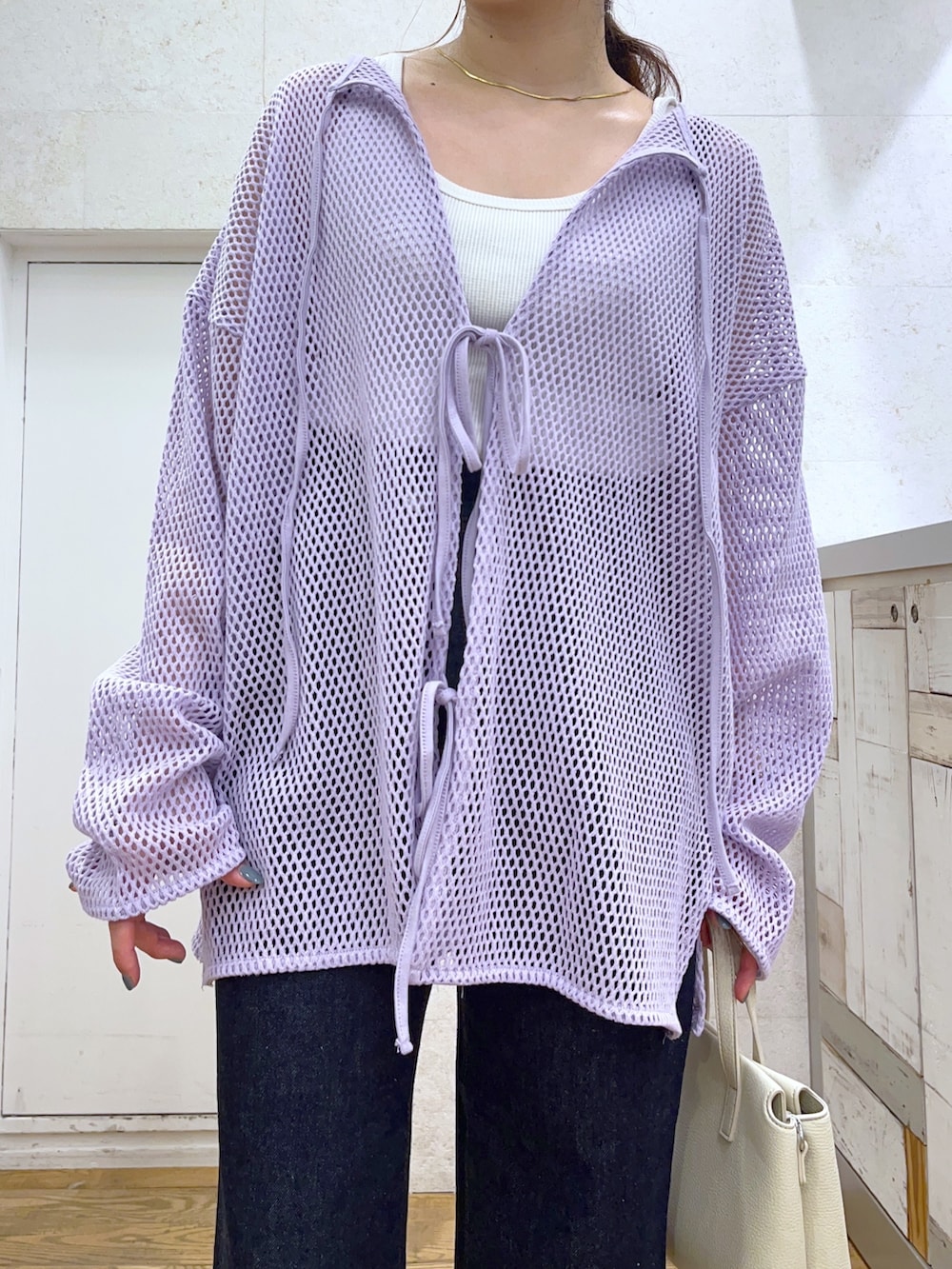 パープル系のカーディガン/ボレロ、ブルー系のパンツ、ホワイト系のバッグを着用したレディースの春コーディネートの3枚目の写真