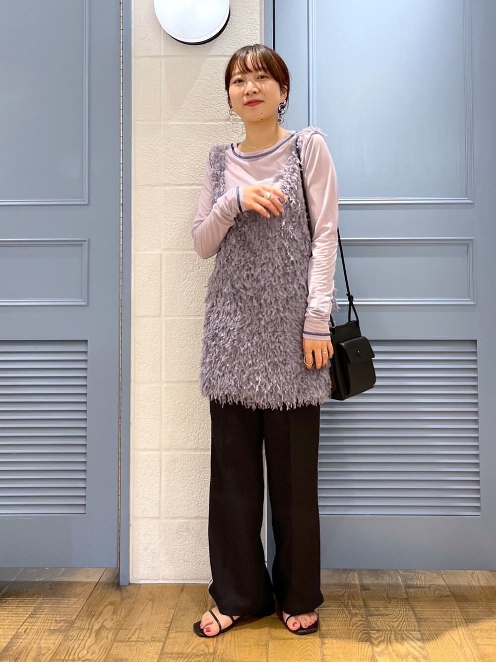 ブラック系のショルダーバッグ、ブラック系のパンツ、ブラック系のシューズを着用したレディースの秋コーディネートの2枚目の写真