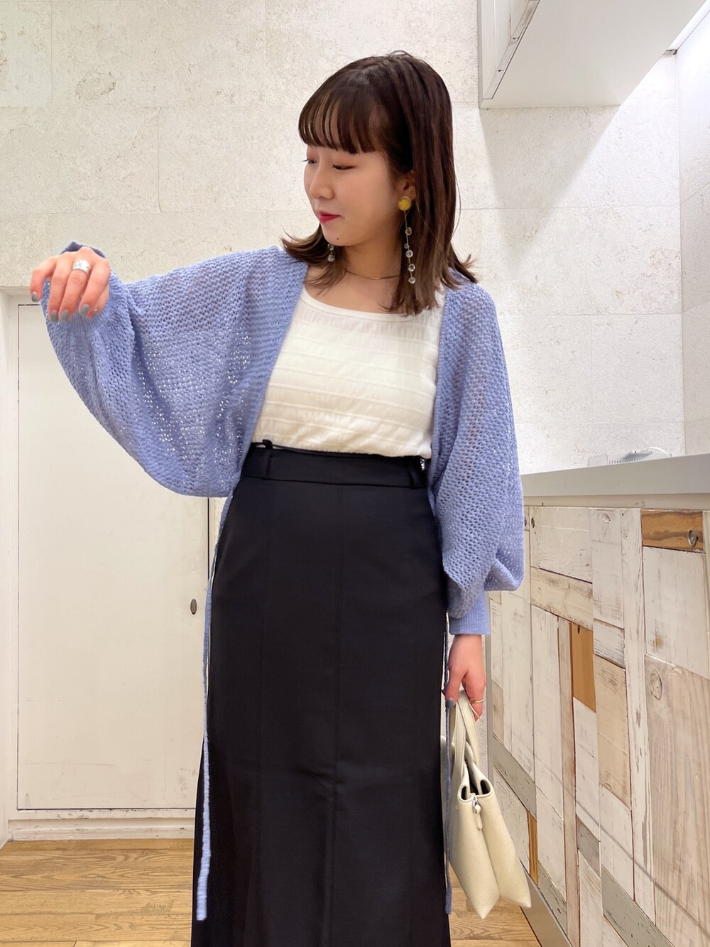 ブルー系のカーディガン/ボレロ、ホワイト系のトップス、ホワイト系のショルダーバッグを着用したレディースの春コーディネートの4枚目の写真