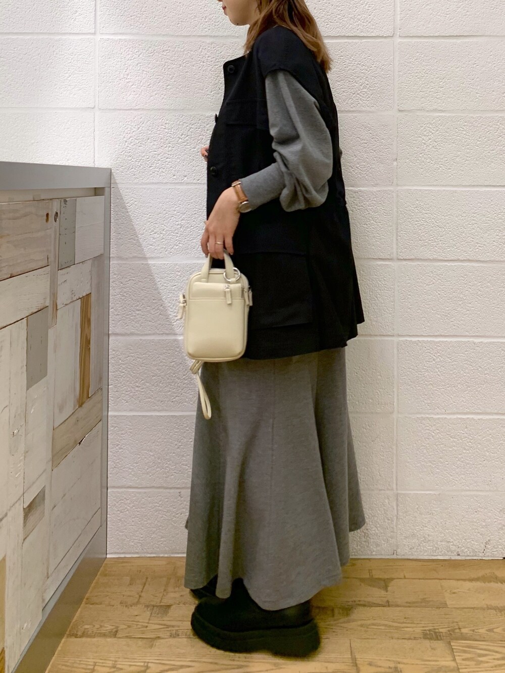 ブラック系のワンピース/ドレス、ブラック系のミリタリージャケット、ブラック系のバッグを着用したレディースの秋コーディネートの4枚目の写真