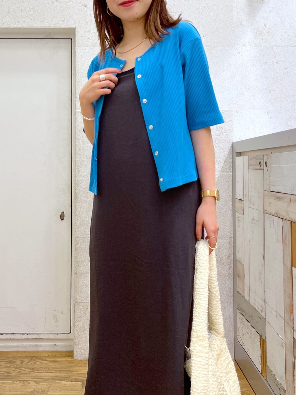 グレー系のワンピース、ブルー系のカーディガン/ボレロ、ホワイト系のハンドバッグを着用したレディースの夏コーディネートの3枚目の写真