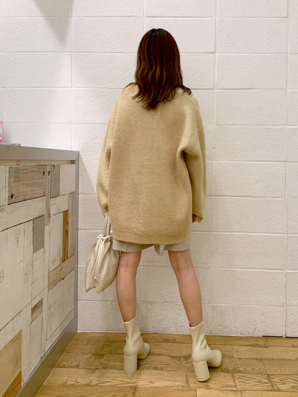 ベージュ系のカーディガン/ボレロ、ホワイト系のその他パンツ、ホワイト系のショルダーバッグを着用したレディースの秋コーディネートの2枚目の写真