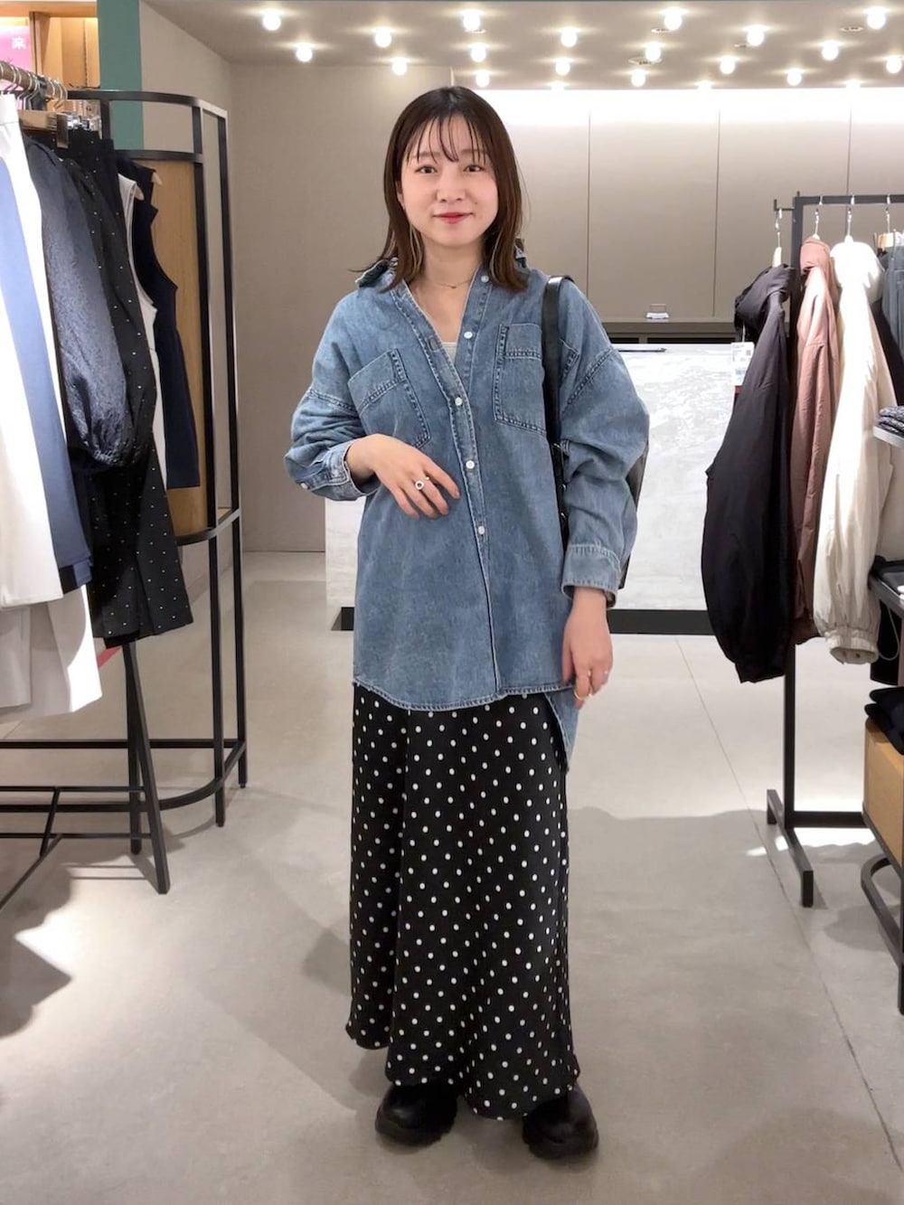 ブラック系のスカート、ブルー系のシャツ/ブラウス、ブラック系のショルダーバッグを着用したレディースの冬コーディネートの2枚目の写真