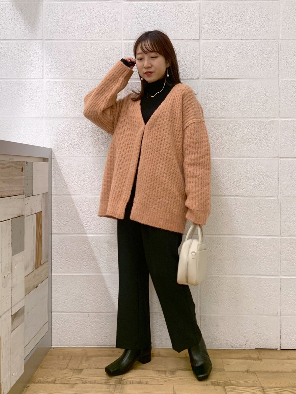 ピンク系のトップス、ブラック系のトップス、ブラック系のスラックスを着用したレディースの秋コーディネートの2枚目の写真