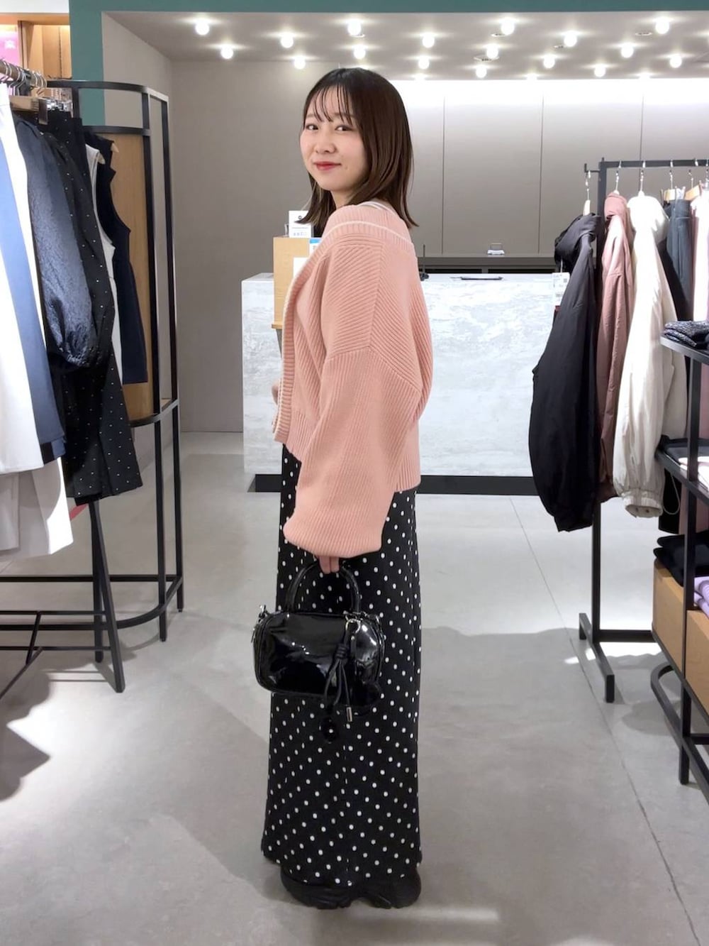 ホワイト系のTシャツ/カットソー、ブラック系のブーツ、ブラック系のスカートを着用したレディースの冬コーディネートの3枚目の写真