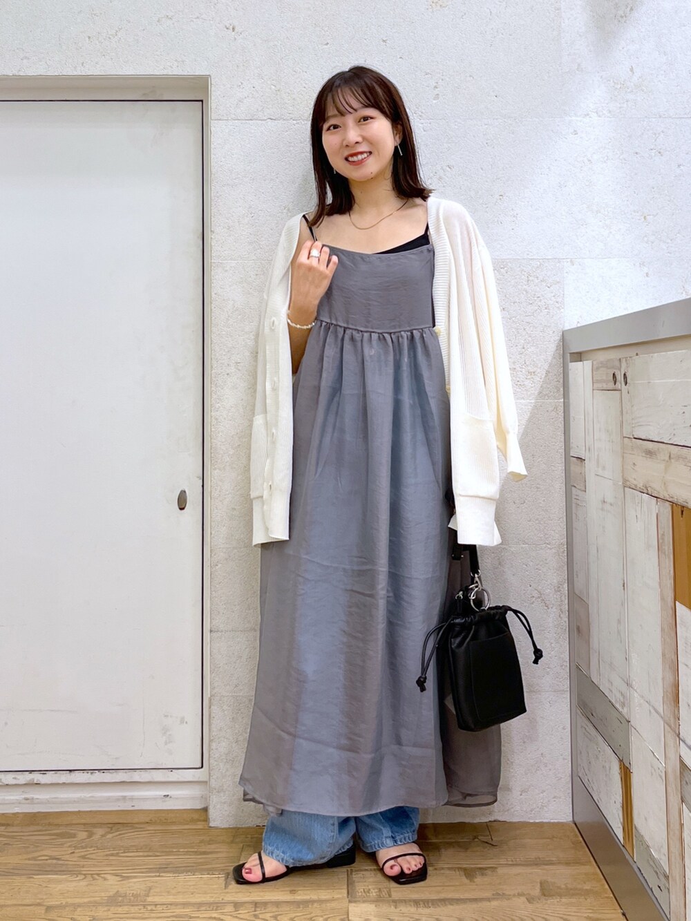 ブラック系のショルダーバッグ、ブラック系のシューズ、グレー系のワンピースを着用したレディースの夏コーディネートの3枚目の写真