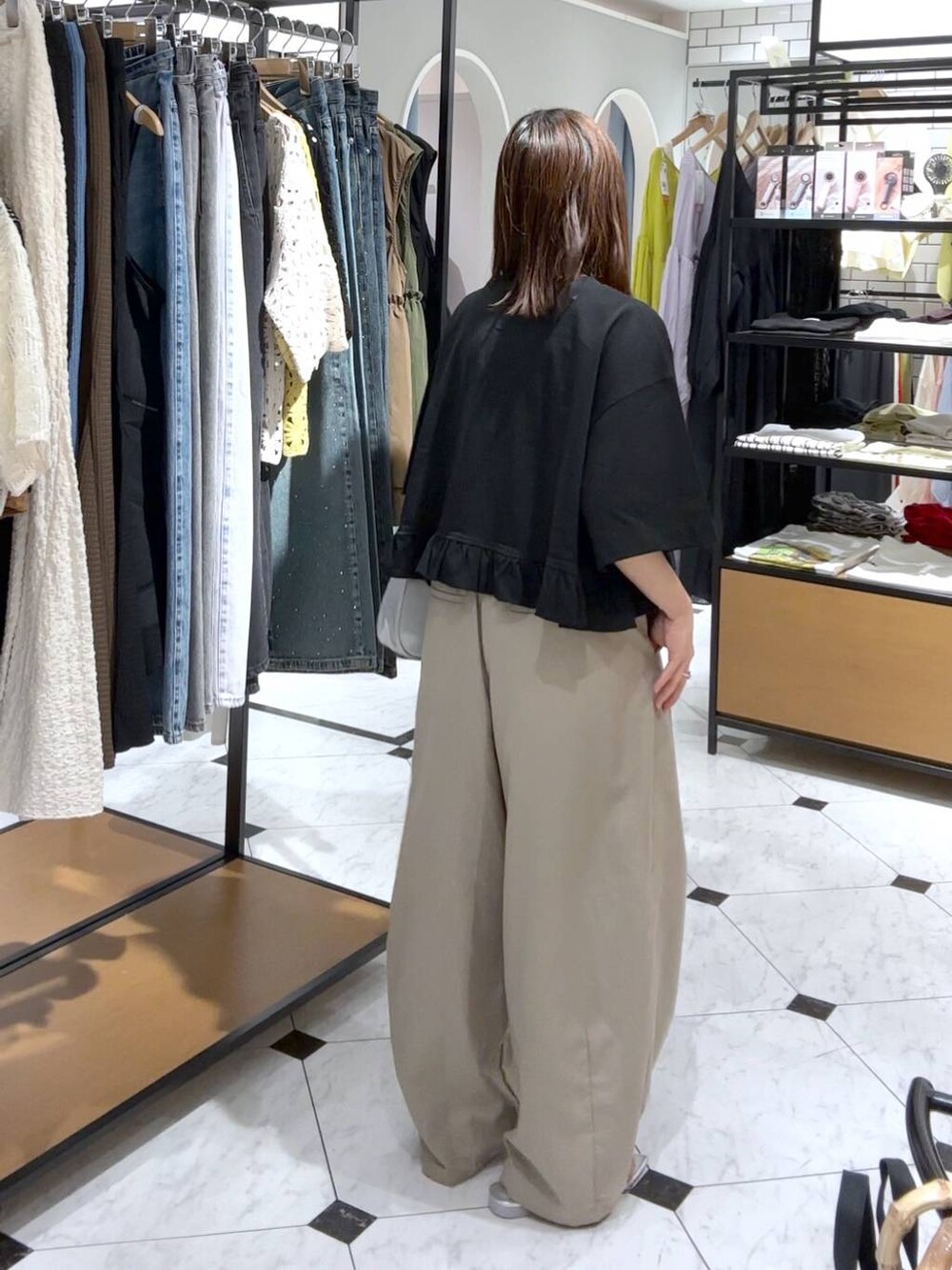 シルバー系のトートバッグ、シルバー系のサンダル、ベージュ系のその他パンツを着用したレディースの夏コーディネートの2枚目の写真