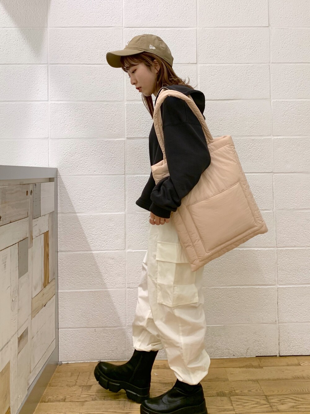 グレー系のトップス、ホワイト系のパンツ、ピンク系のショルダーバッグを着用したレディースの秋コーディネートの3枚目の写真