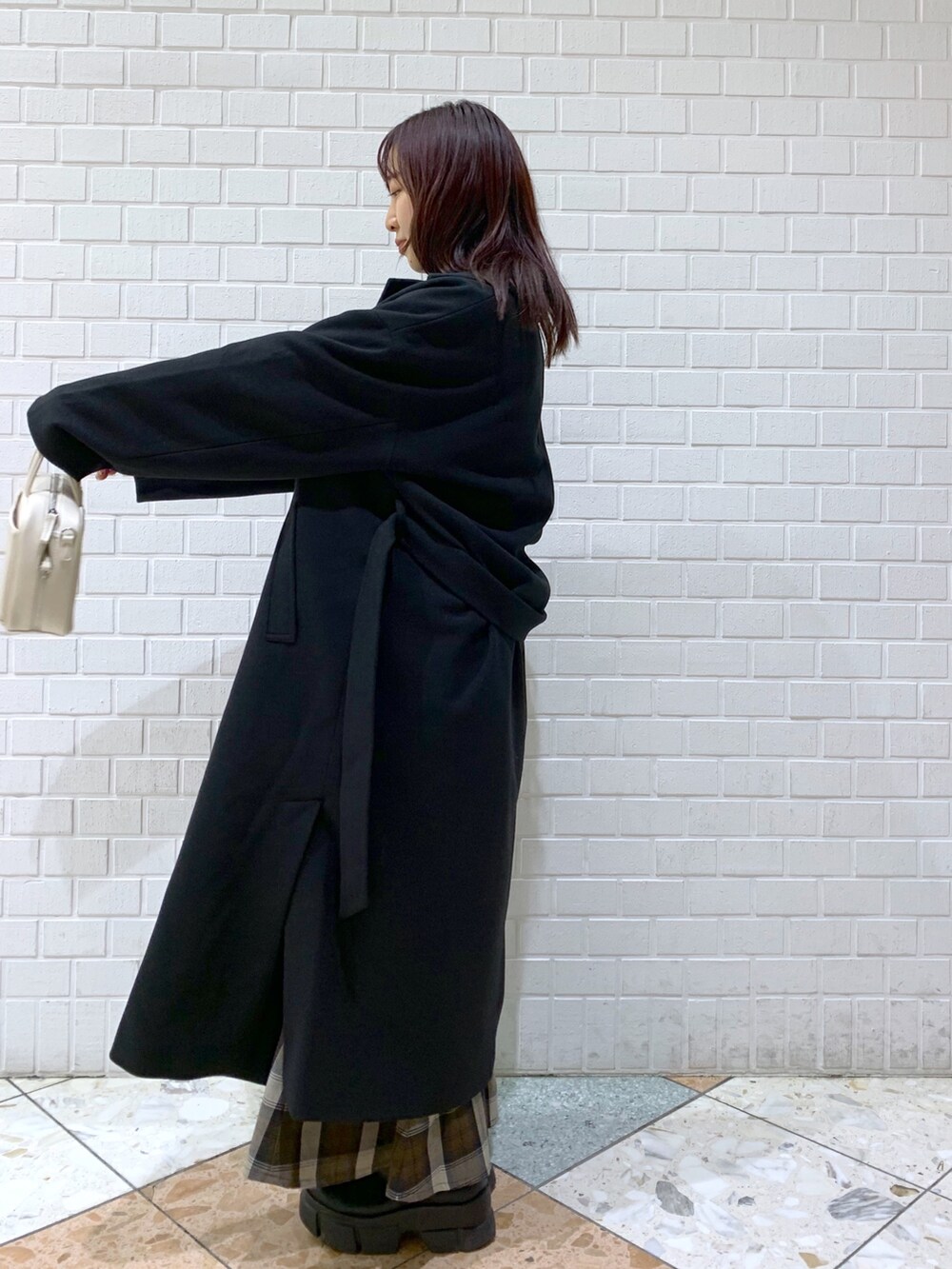 ブラック系のジャケット/アウター、ブルー系のトップス、ブラウン系のスカートを着用したレディースの冬コーディネートの3枚目の写真