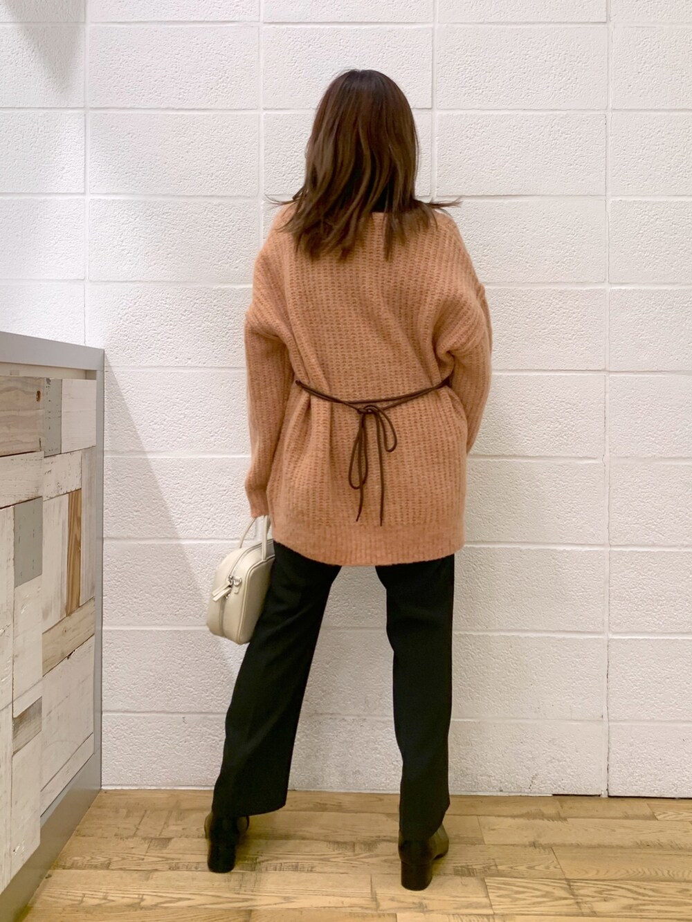 ピンク系のトップス、ブラック系のトップス、ブラック系のスラックスを着用したレディースの秋コーディネートの3枚目の写真