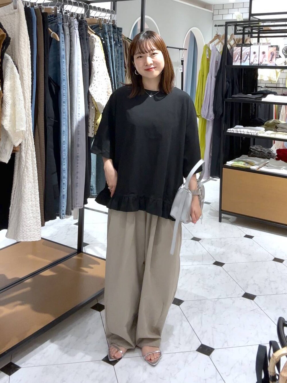 シルバー系のトートバッグ、シルバー系のサンダル、ベージュ系のその他パンツを着用したレディースの夏コーディネートの4枚目の写真