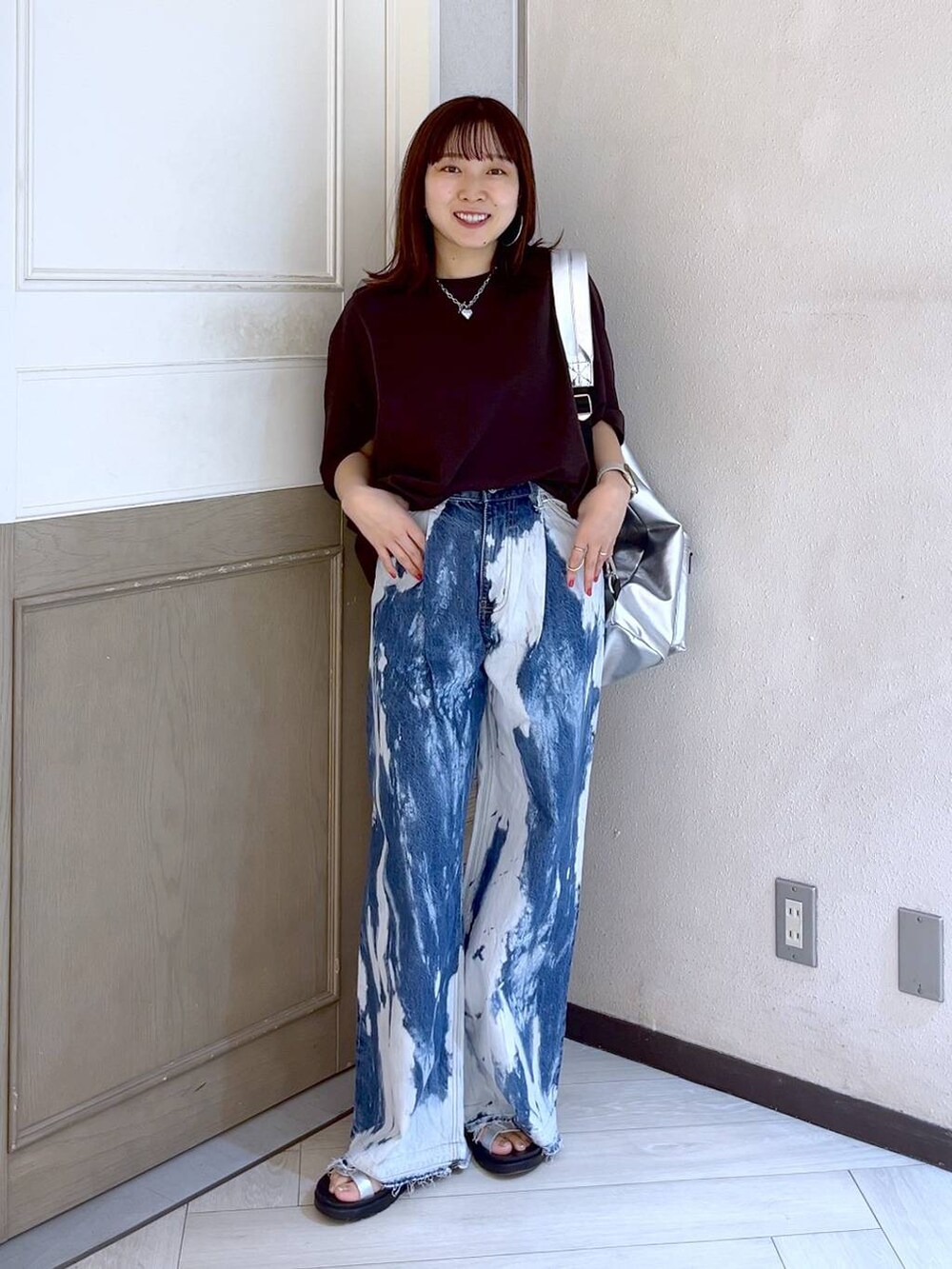 ブルー系のデニムパンツ、シルバー系のスニーカー、ブラウン系のTシャツ/カットソーを着用したレディースの夏コーディネートの2枚目の写真