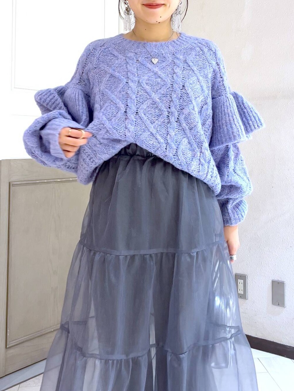 ブラック系のブーツ、パープル系のニット/セーター、シルバー系のボストンバッグを着用したレディースの秋コーディネートの5枚目の写真