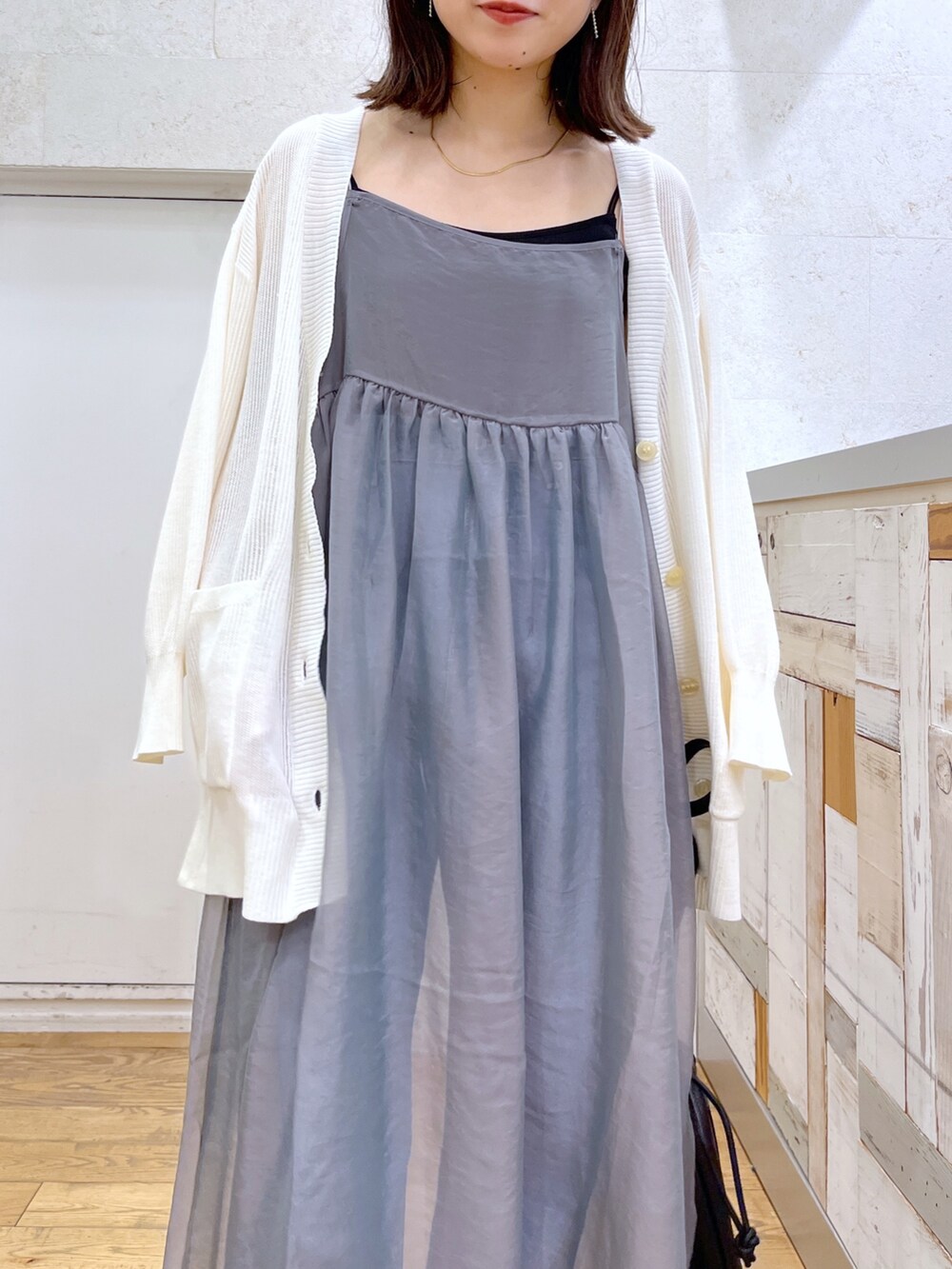 ブラック系のショルダーバッグ、ブラック系のシューズ、グレー系のワンピースを着用したレディースの夏コーディネートの4枚目の写真