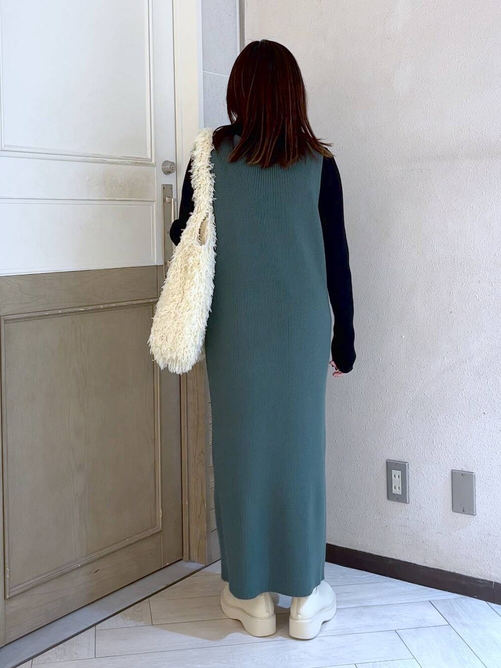 ホワイト系のブーツ、グリーン系のワンピース、ホワイト系のトートバッグを着用したレディースの冬コーディネートの5枚目の写真