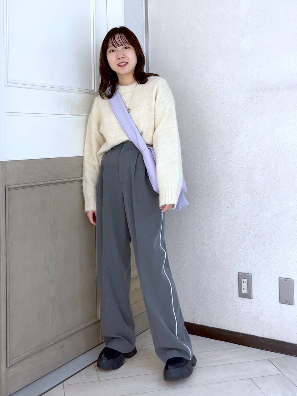 ブラック系のブーツ、グレー系のその他パンツ、パープル系のショルダーバッグを着用したレディースの冬コーディネートの2枚目の写真