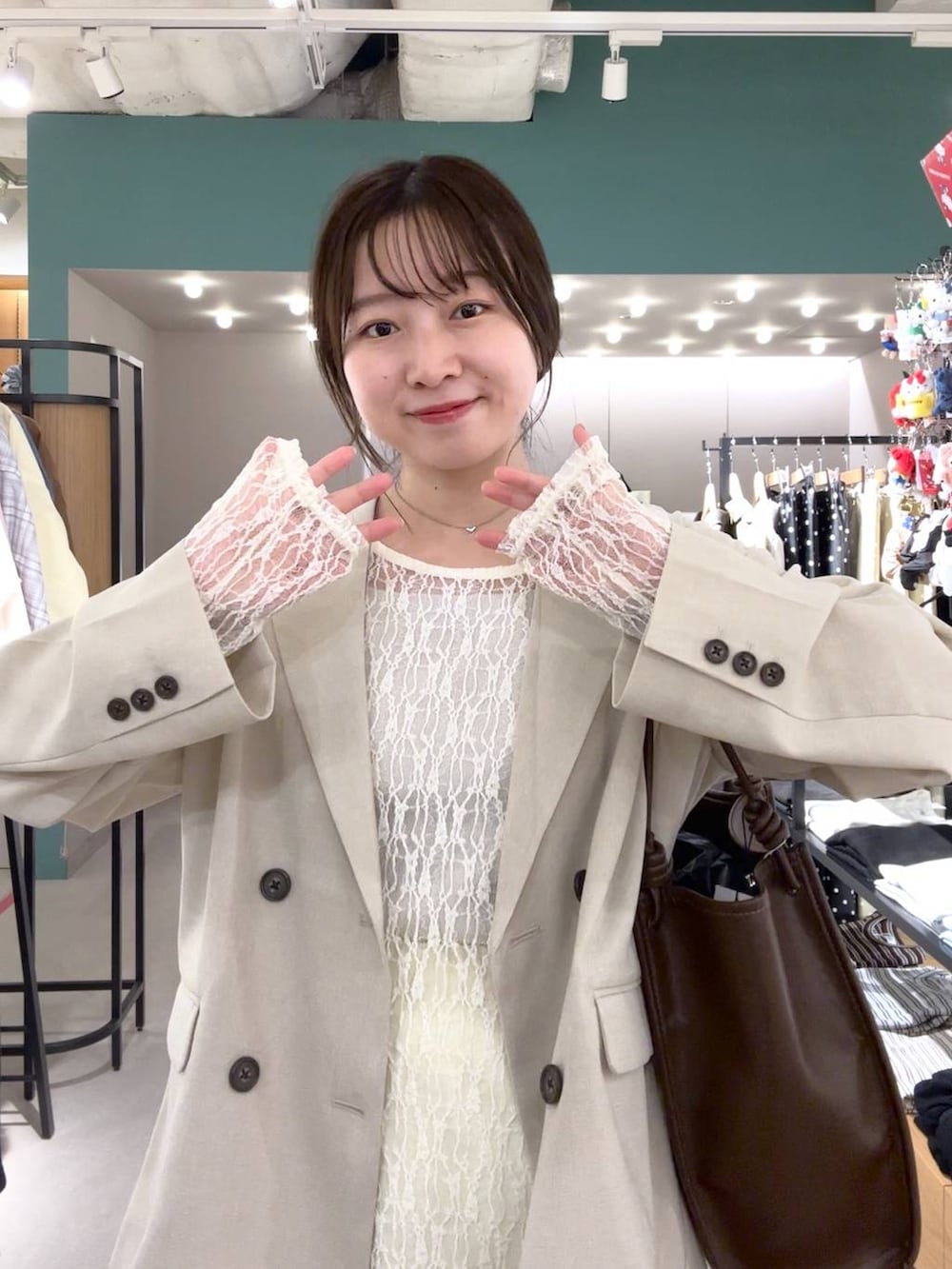 イエロー系のスカート、ブラック系のパンプス、ベージュ系のその他アウターを着用したレディースの春コーディネートの4枚目の写真