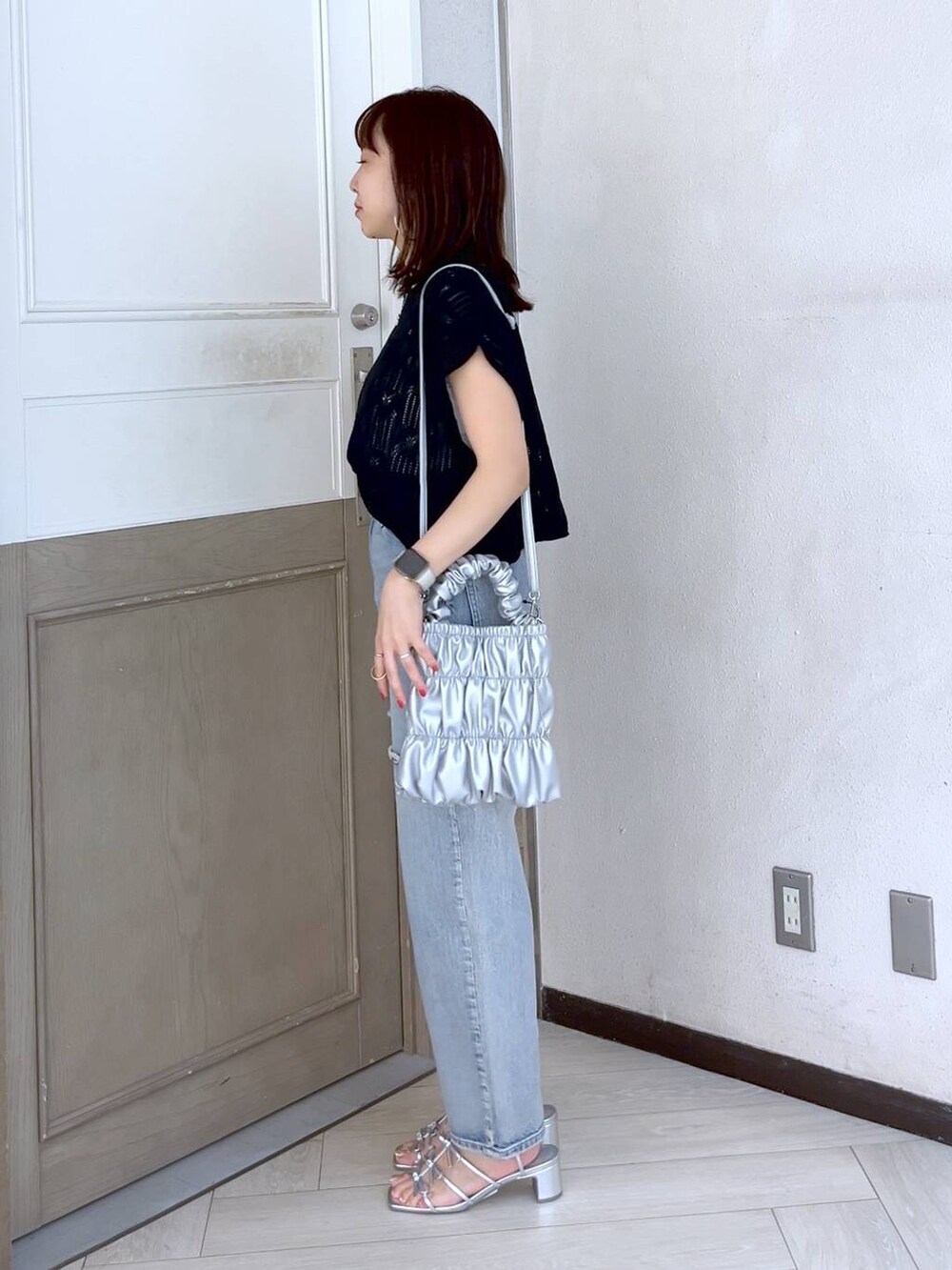 シルバー系のサンダル、ブルー系のデニムパンツ、ブラック系のニット/セーターを着用したレディースの夏コーディネートの4枚目の写真