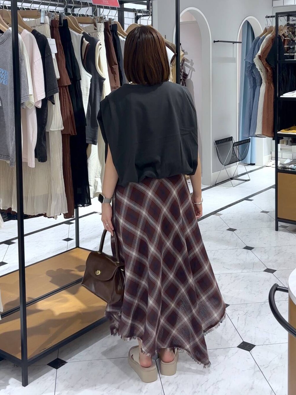 ホワイト系のサンダル、ブラウン系のボストンバッグ、グレー系のTシャツ/カットソーを着用したレディースの夏コーディネートの3枚目の写真