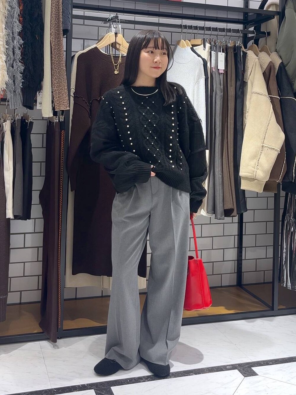 グレー系のその他パンツ、ブラック系のニット/セーター、ブラック系のバレエシューズを着用したレディースの冬コーディネートの2枚目の写真