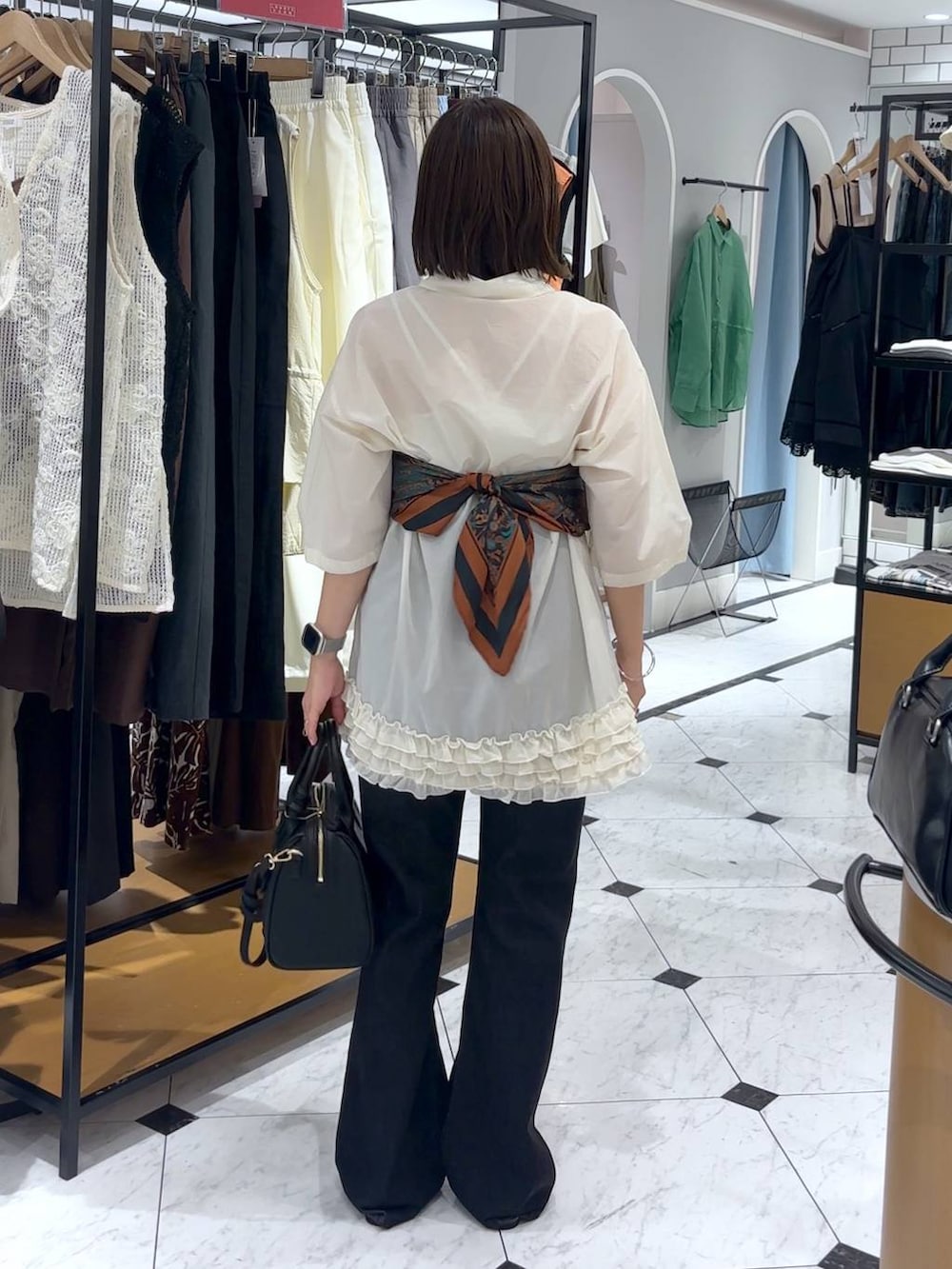 ブラック系のサンダル、ブラック系のショルダーバッグ、ブラック系のデニムパンツを着用したレディースの夏コーディネートの4枚目の写真