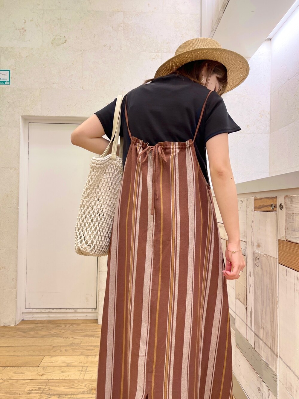 ブラック系のTシャツ/カットソー、ブラウン系のワンピース、ホワイト系のトートバッグを着用したレディースの春コーディネートの5枚目の写真