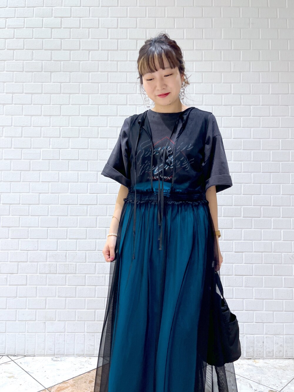 グレー系のTシャツ/カットソー、ブラック系のワンピース、ブルー系のスカートを着用したレディースの春コーディネートの4枚目の写真