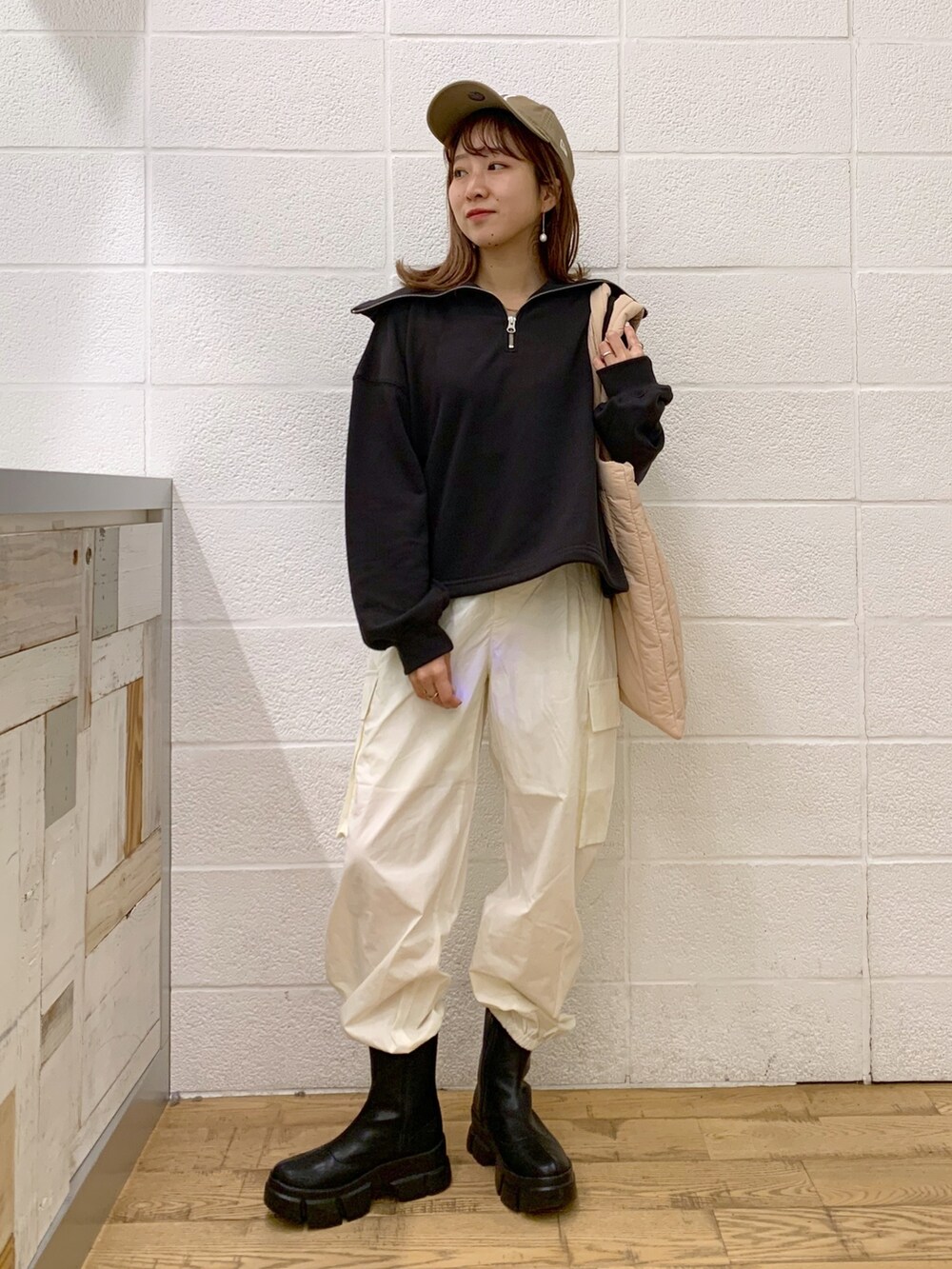 グレー系のトップス、ホワイト系のパンツ、ピンク系のショルダーバッグを着用したレディースの秋コーディネートの2枚目の写真