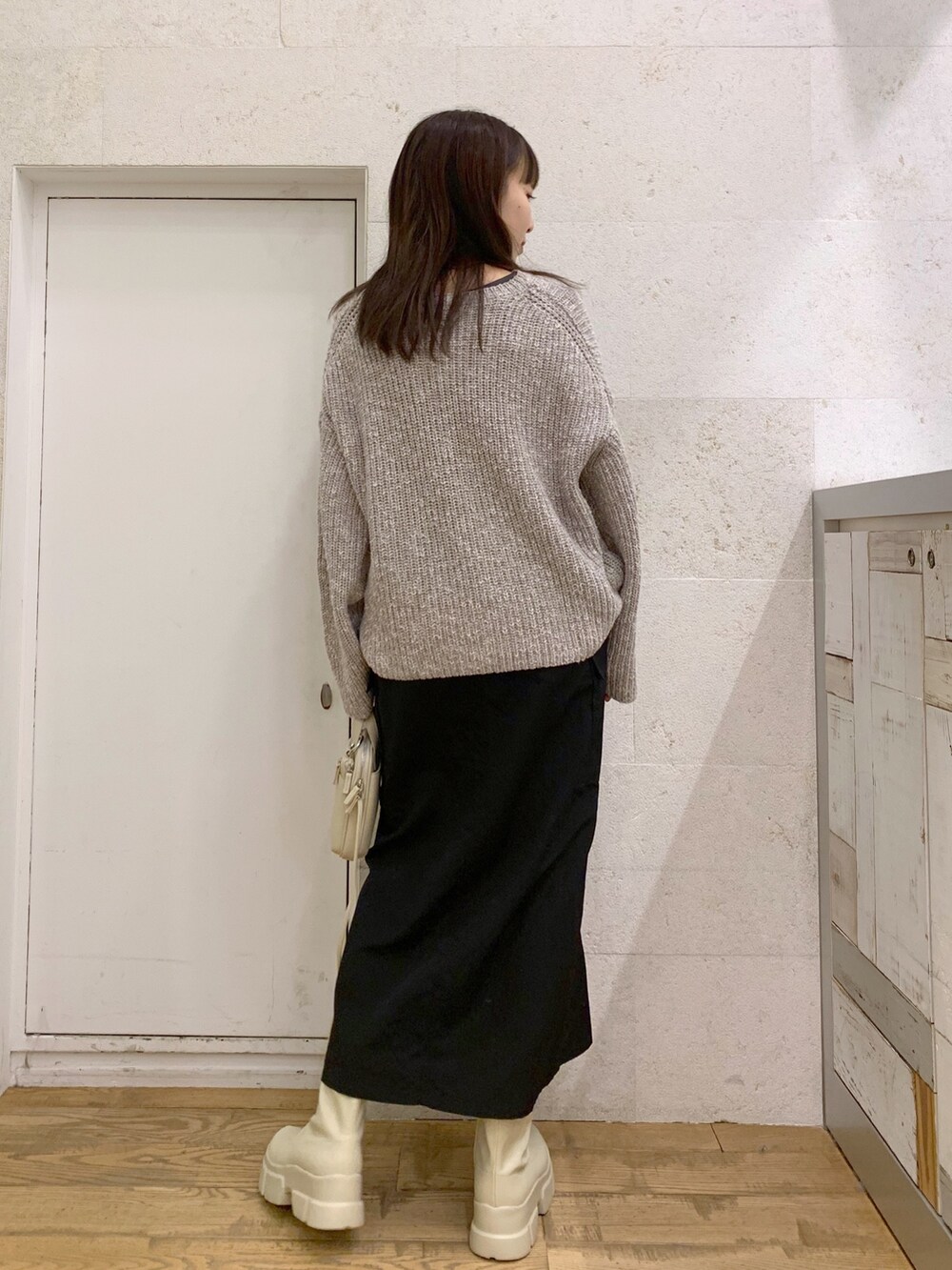 グレー系のニット/セーター、ブラック系のスカート、ブラック系のバッグを着用したレディースの冬コーディネートの3枚目の写真