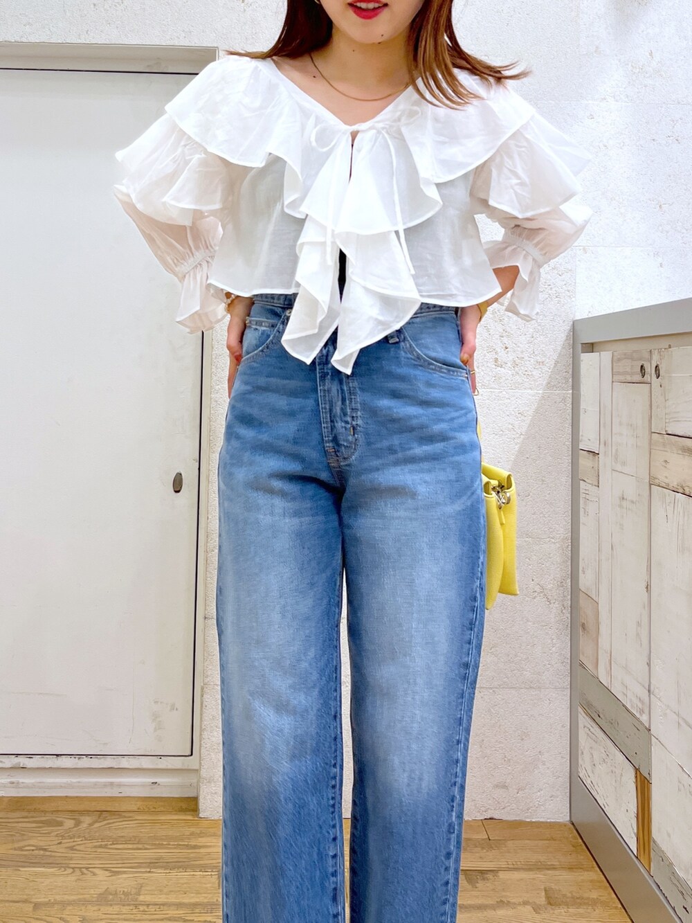 ホワイト系のシャツ/ブラウス、ブルー系のパンツ、イエロー系のバッグを着用したレディースの夏コーディネートの4枚目の写真