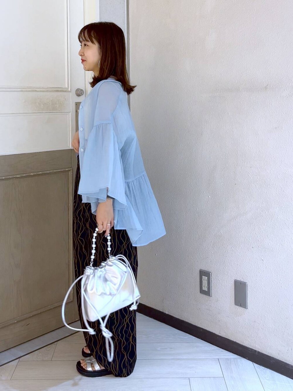 ブラック系のその他パンツ、シルバー系のスニーカー、シルバー系のショルダーバッグを着用したレディースの夏コーディネートの2枚目の写真