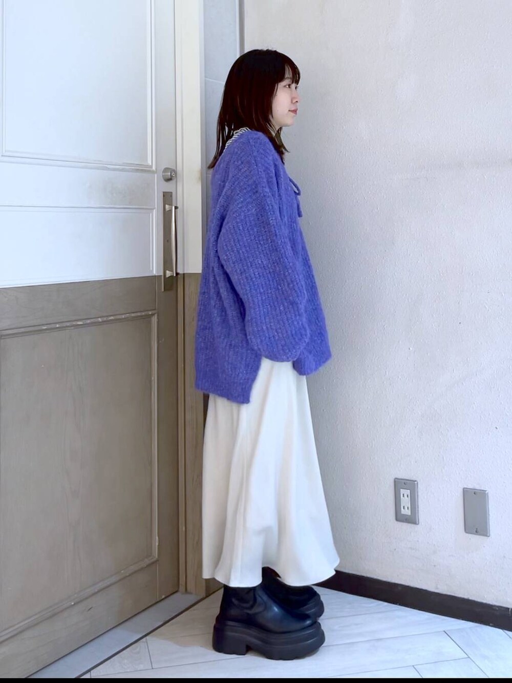 ホワイト系のTシャツ/カットソー、ホワイト系のスカート、パープル系のニット/セーターを着用したレディースの冬コーディネートの4枚目の写真