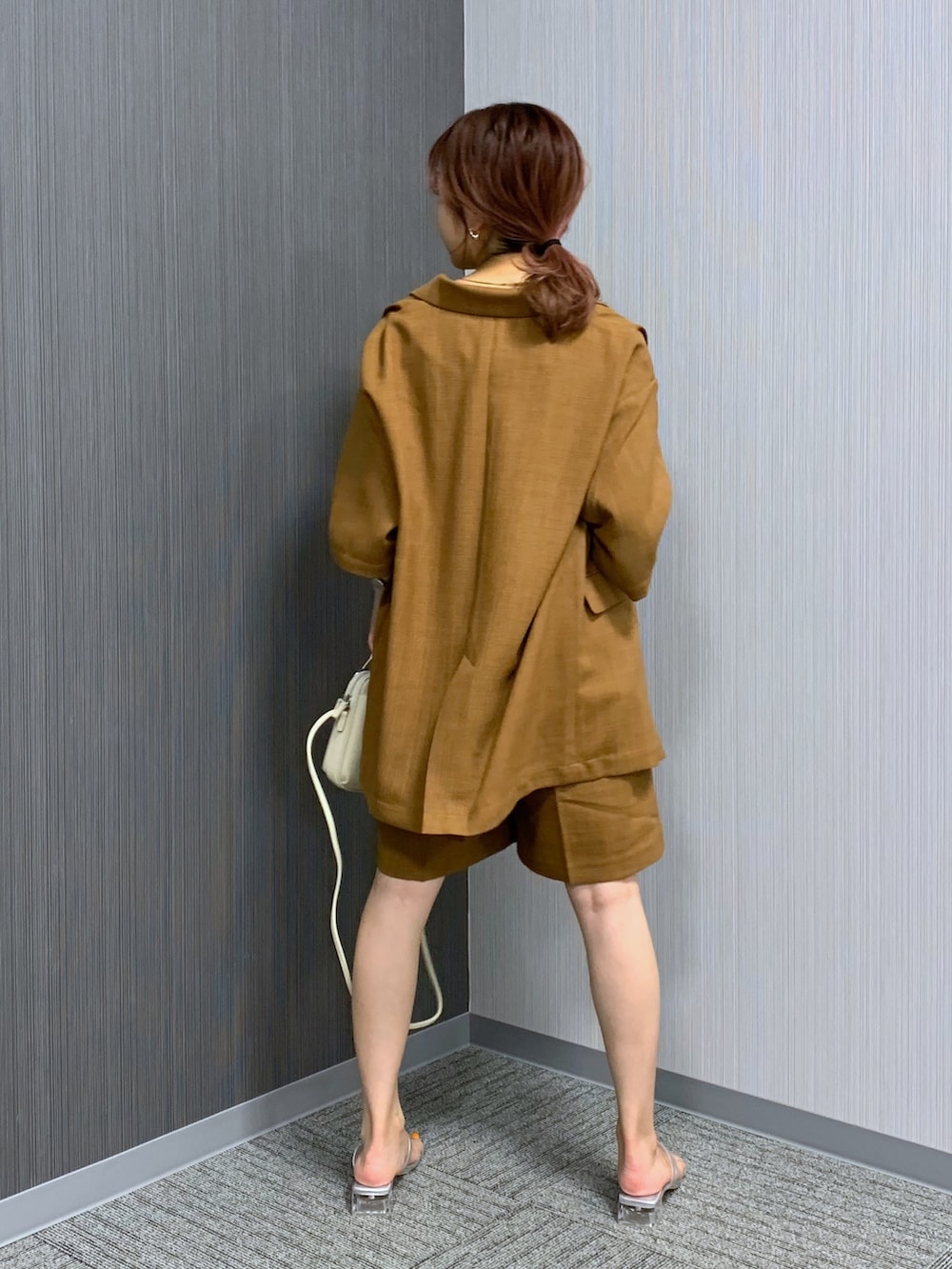 ブラウン系のジャケット/アウター、ブラウン系のパンツ、ホワイト系のタンクトップを着用したレディースの夏コーディネートの3枚目の写真