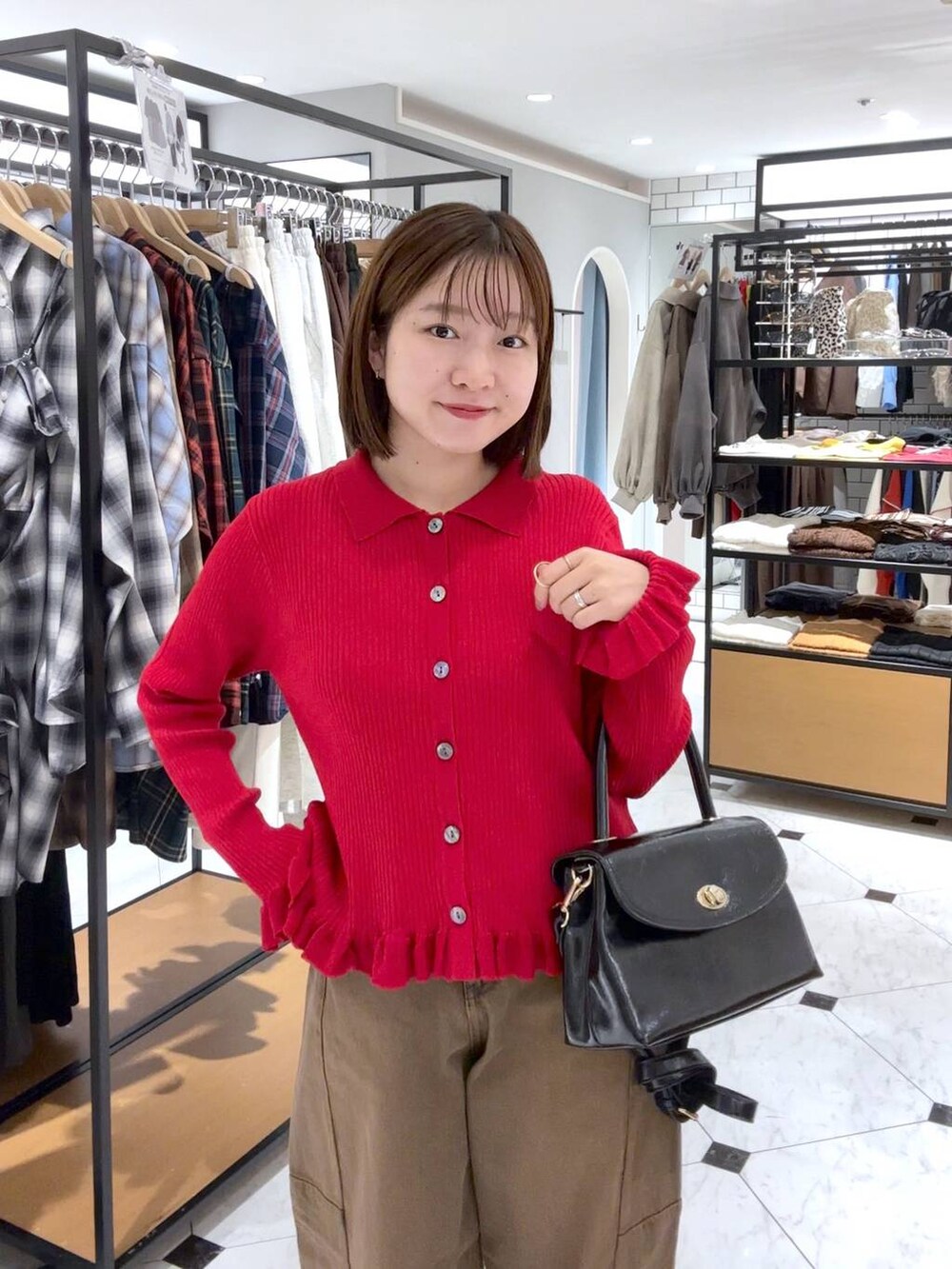 ブラウン系のデニムパンツ、ブラック系のボストンバッグ、ブラック系のパンプスを着用したレディースの秋コーディネートの3枚目の写真