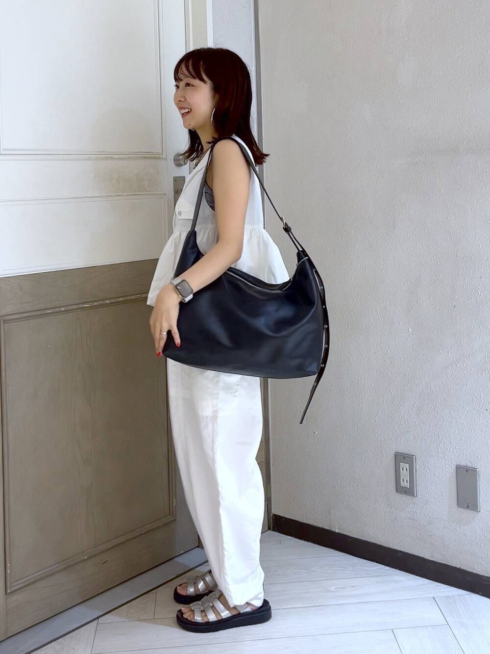 ホワイト系のカーゴパンツ、ホワイト系のベスト、シルバー系のスニーカーを着用したレディースの夏コーディネートの3枚目の写真